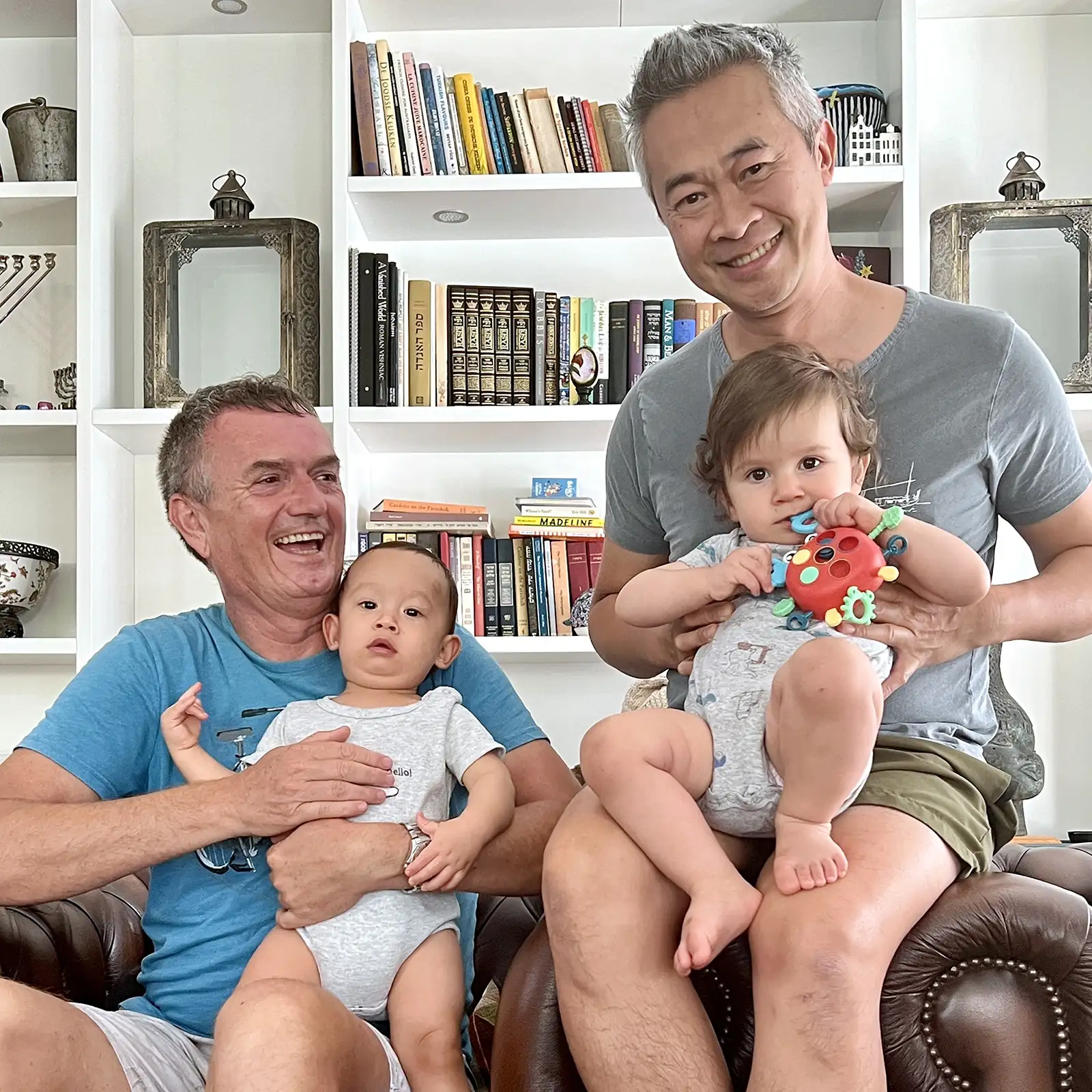 happy gay couple at home with their children
